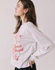 Side view of woman wearing Chaser’s Spirits Bright Light Grey Long Sleeve on a light gray background