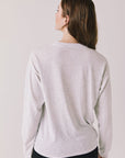 Back view of woman wearing Chaser’s Spirits Bright Light Grey Long Sleeve on a light gray background