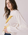 Side view of woman wearing Chaser’s starry white Willie Nelson Luck Texas Long Sleeve showing sleeve and graphic detail on a light background (licensed band collaboration)