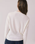 Back view of woman wearing Chaser’s starry white Willie Nelson Luck Texas Long Sleeve on a light background (licensed band collaboration)