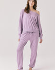Woman wearing Chaser's Bellini Amethyst Purple Pullover with matching pants on a plain background