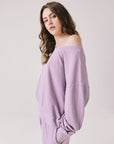 Side view of woman wearing Chaser's Bellini Amethyst Purple Pullover with matching pants on a plain background