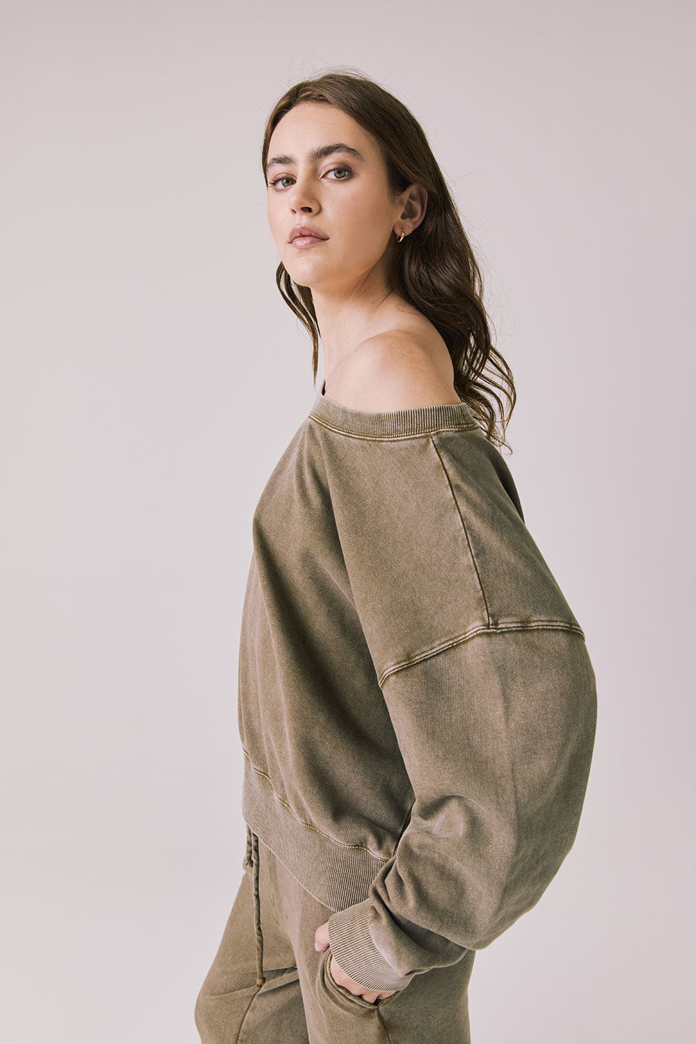 Side view of a woman wearing Chaser's Bellini Ginger Brown Pullover and matching pants on a white background