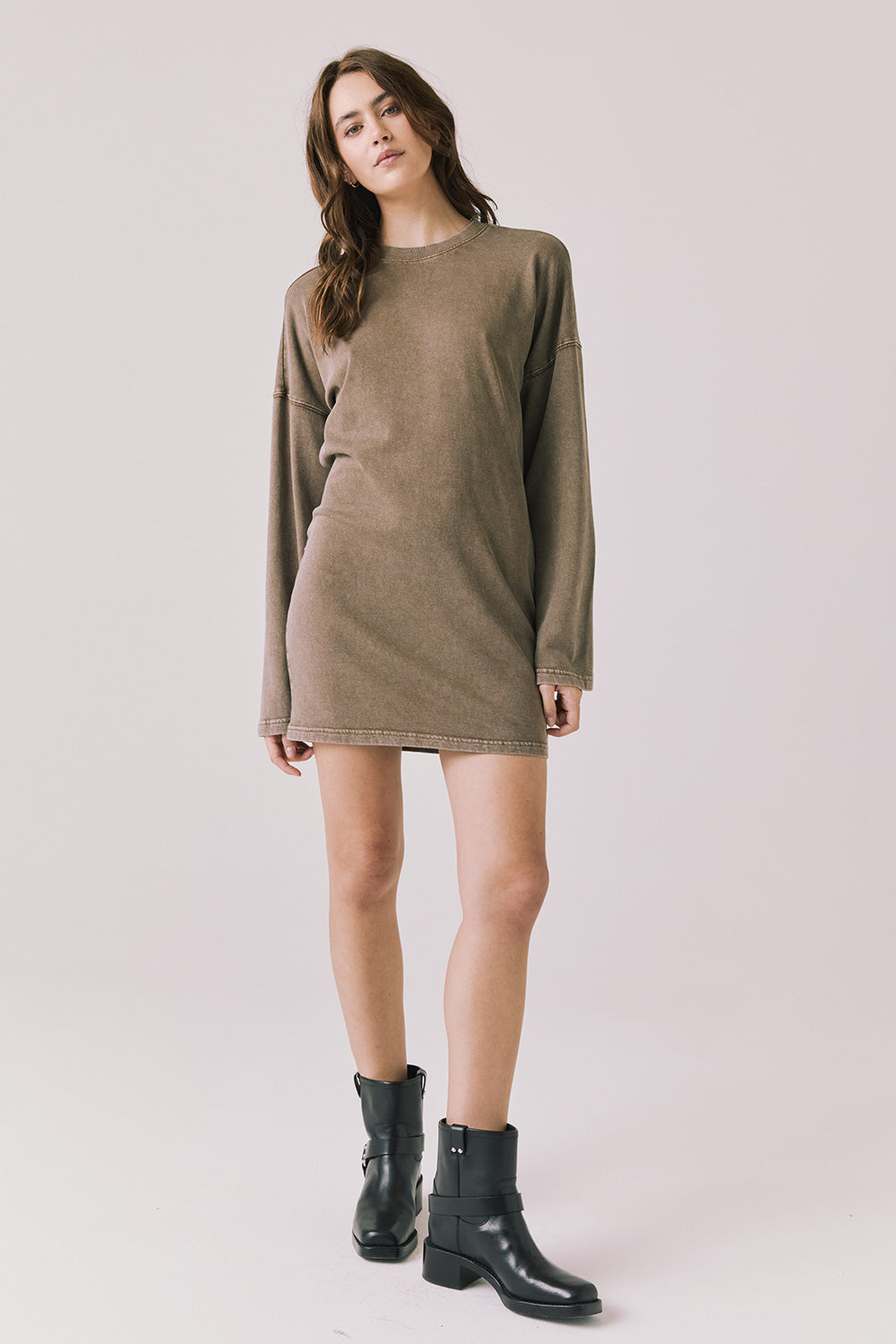 Full body view of woman wearing Chaser’s Ginger Brown Margarita Mini Dress with black boots on a plain background