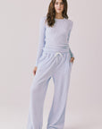 Full body view of woman wearing Chaser’s Spritz Long Sleeve with matching Brandy Skyway Blue Joggers on a white background