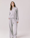 Woman wearing the Abilene Light Heather Grey Zip Up Hoodie with matching pants on a white background