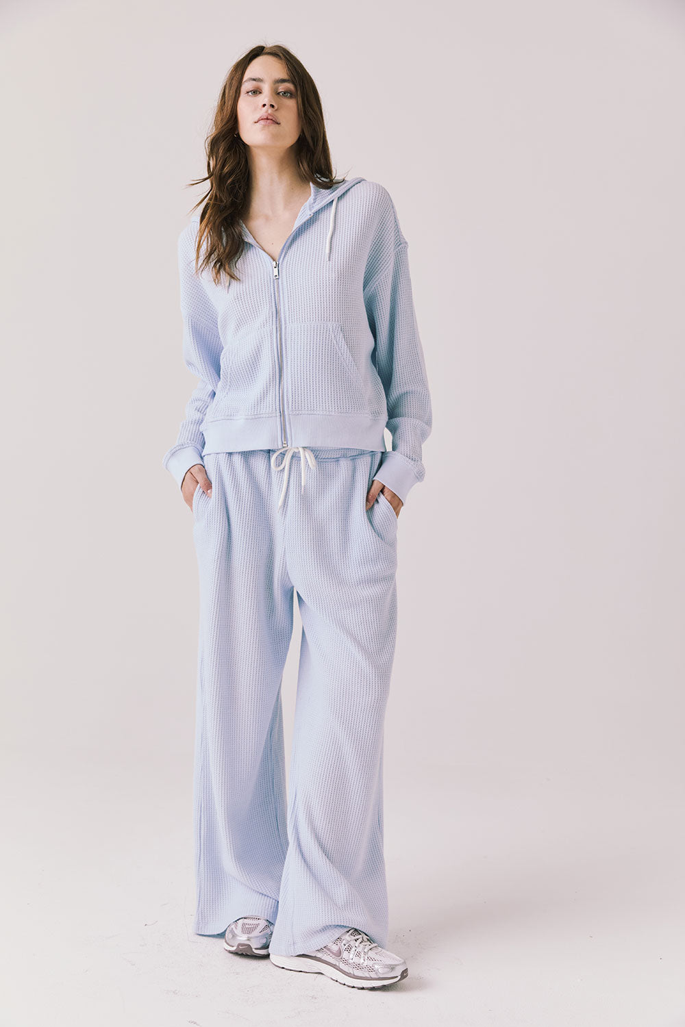 Woman wearing the Abilene Light Skyway Blue Zip Up Hoodie with matching pants on a white background