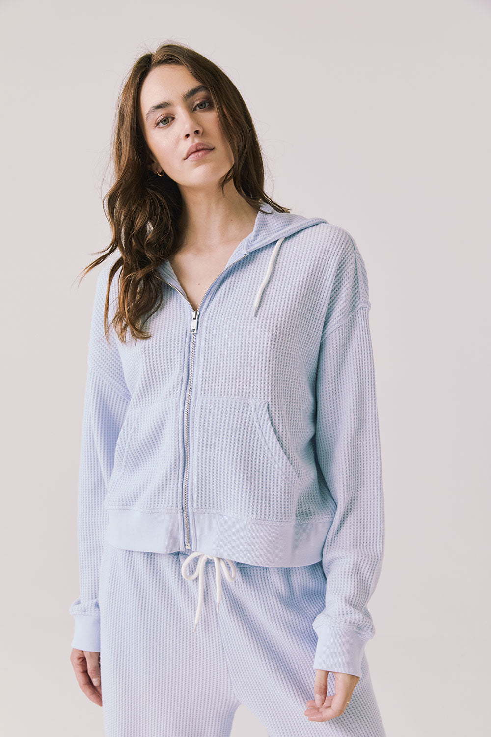 Woman wearing the Abilene Light Skyway Blue Zip Up Hoodie with matching pants on a white background