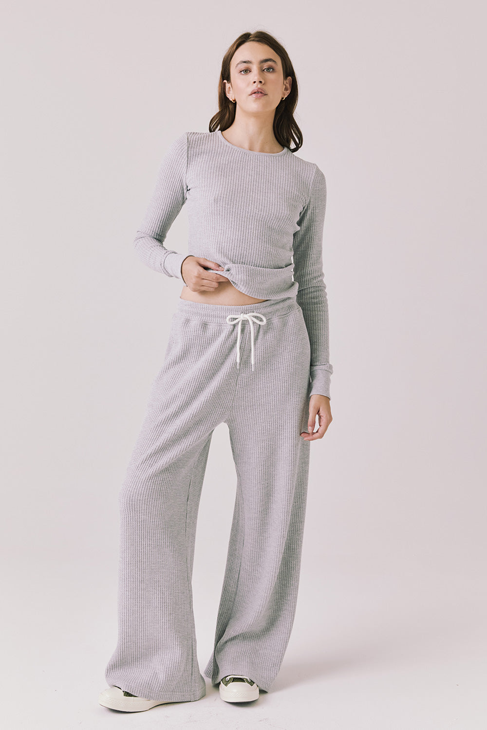 Full body view of woman wearing Chaser’s Brandy Light Heather Grey Joggers with matching Spritz Long Sleeve on a white background.