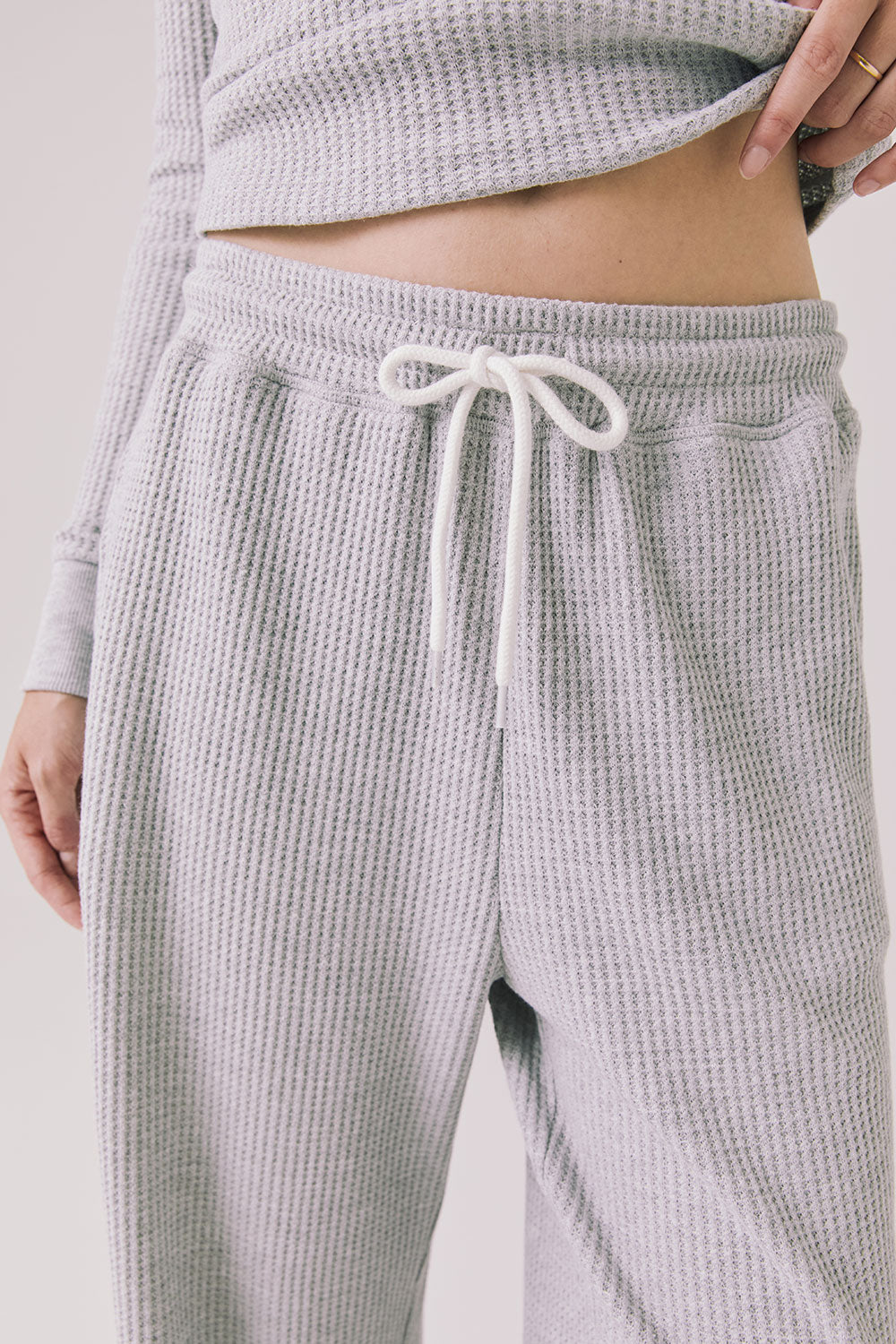Front view of woman wearing Chaser’s Brandy Light Heather Grey Joggers on a white background