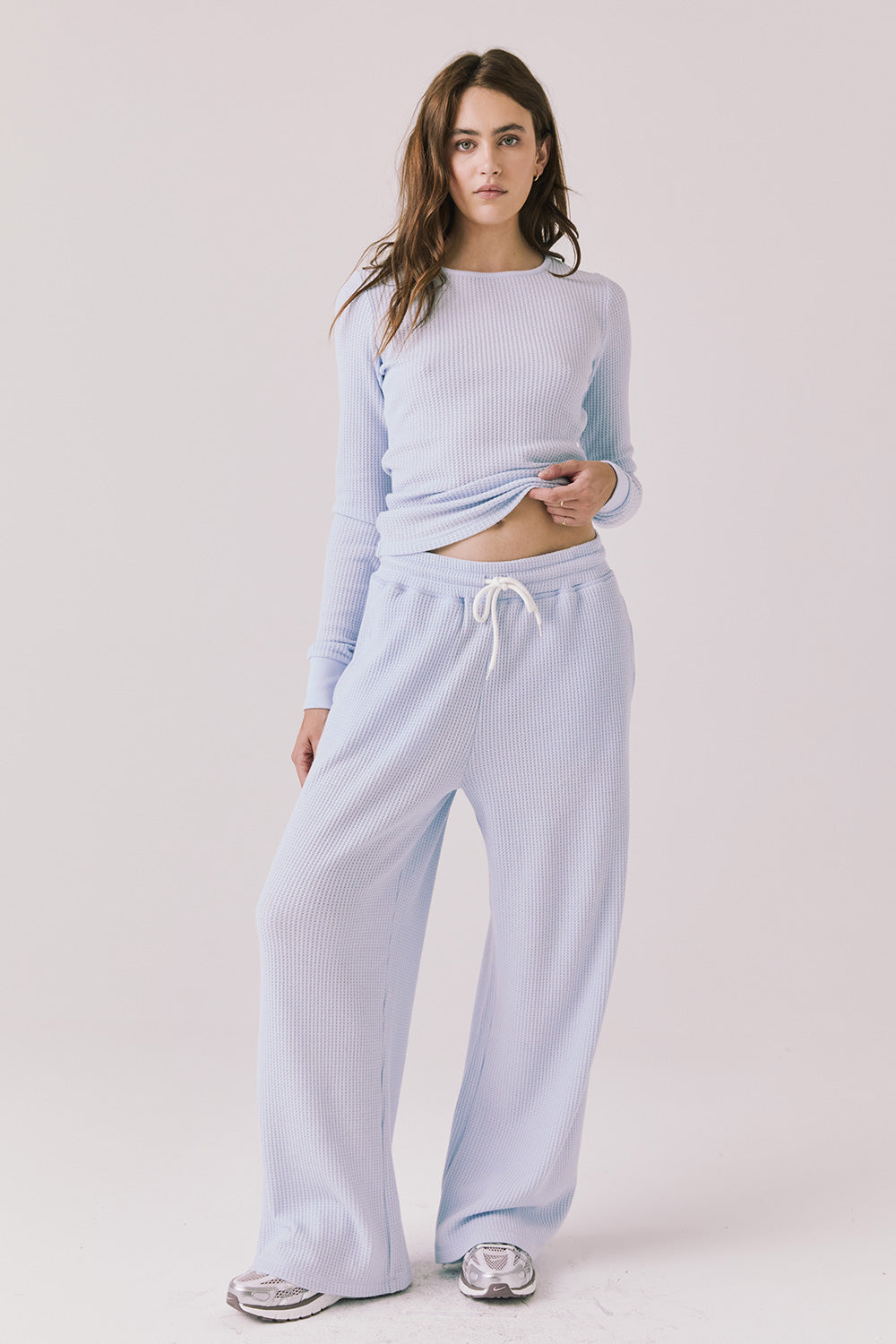 Full body view of woman wearing Chaser’s Brandy Skyway Blue Joggers with matching Spritz Long Sleeve on a white background