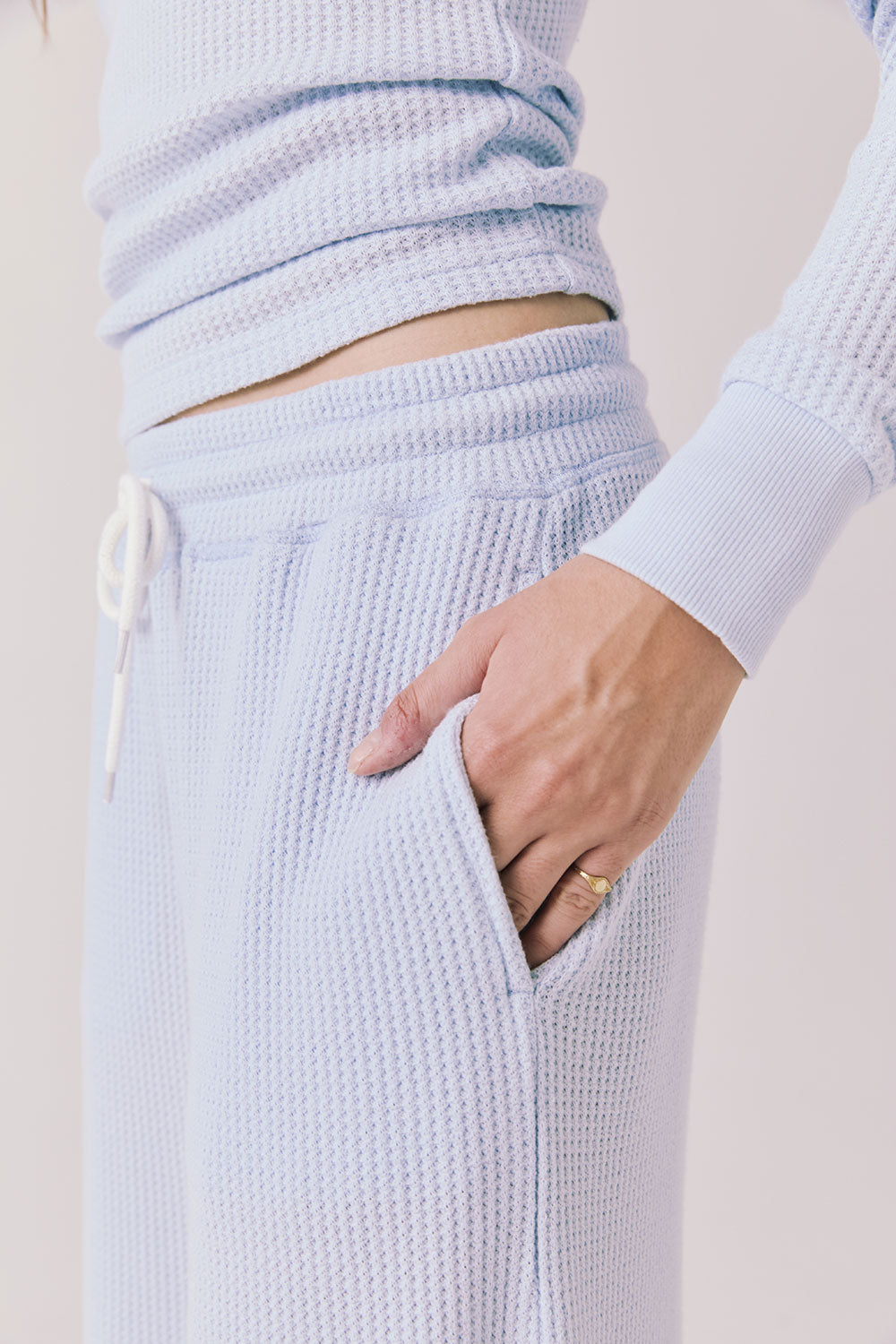 Side view of woman wearing Chaser’s Brandy Skyway Blue Joggers on a white background