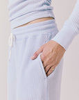 Side view of woman wearing Chaser’s Brandy Skyway Blue Joggers on a white background