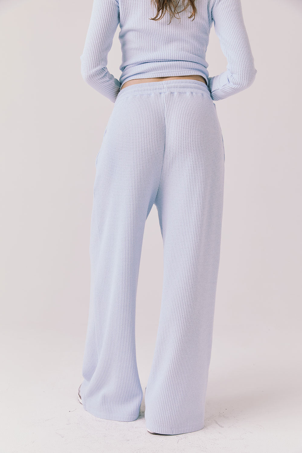 Back view of woman wearing Chaser’s Brandy Skyway Blue Joggers on a white background