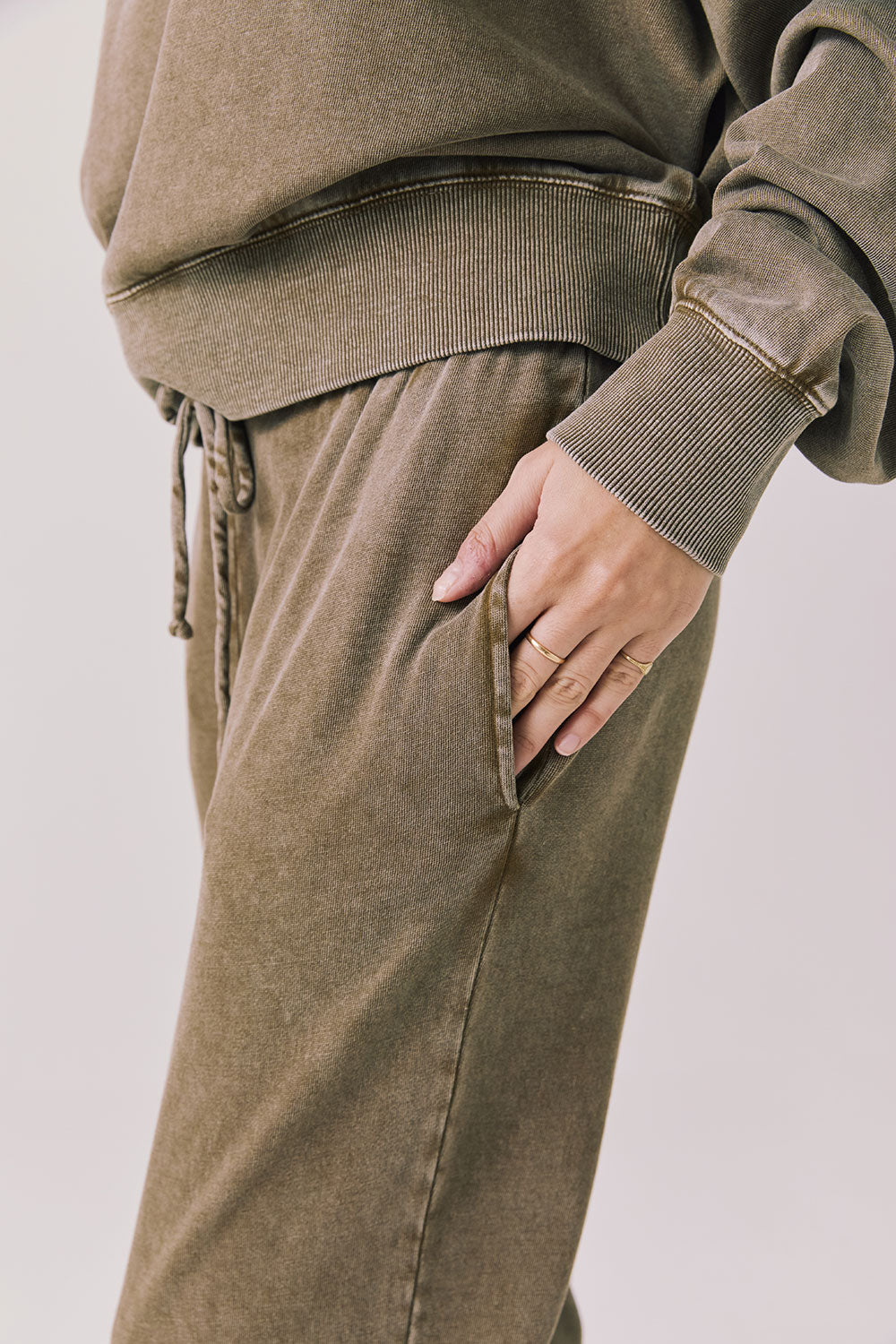 Side view of woman wearing Chaser’s Ginger Brown Manhattan Joggers on a white background