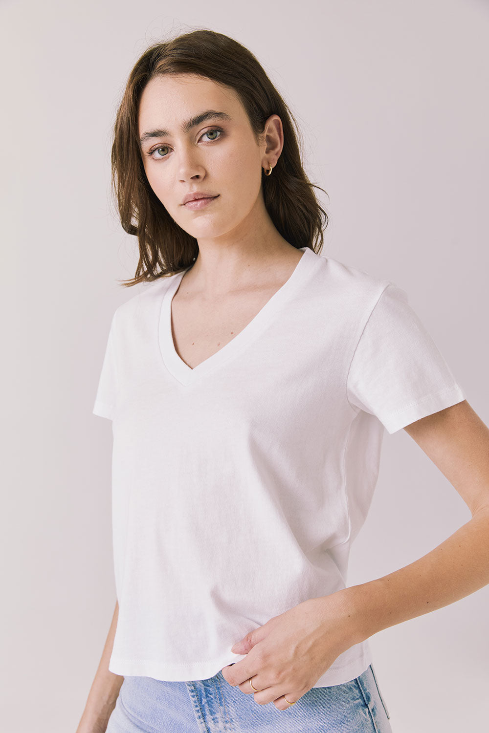 Side view of woman wearing Chaser’s Gimlet White Tee on a plain background