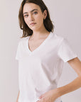 Side view of woman wearing Chaser’s Gimlet White Tee on a plain background