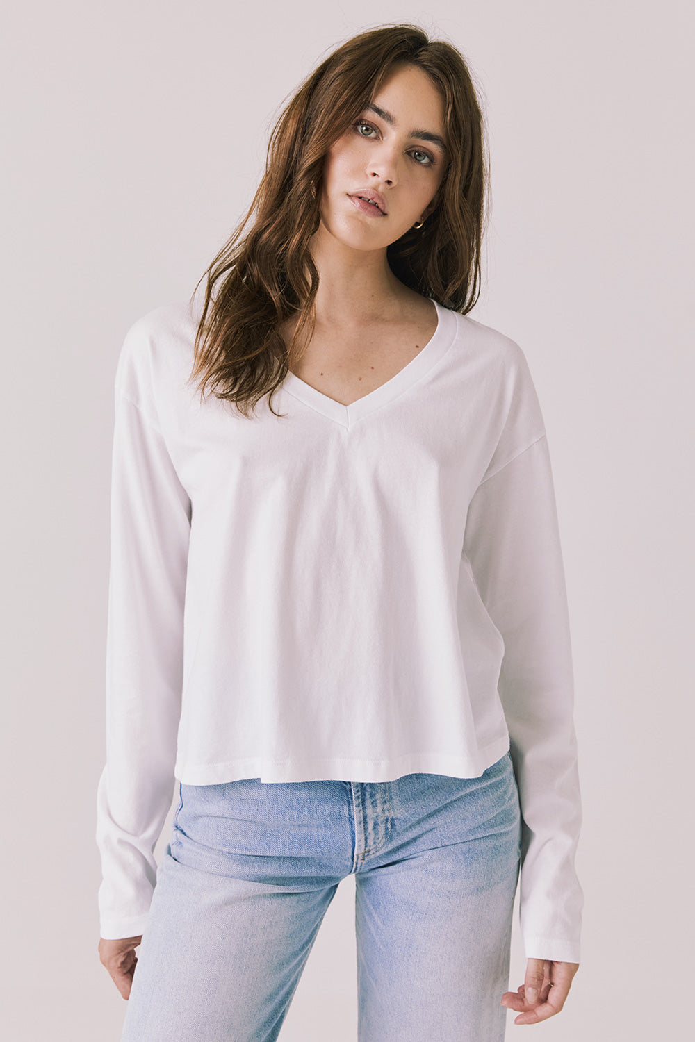 Front view of woman wearing Chaser’s Whiskey White Long Sleeve with classic crew neckline on a plain background