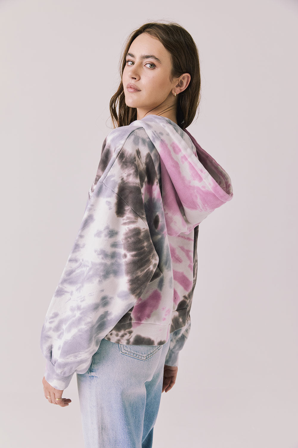 Back view of woman wearing Chaser’s Heart Tie Dye Zip Up Hoodie on a white background