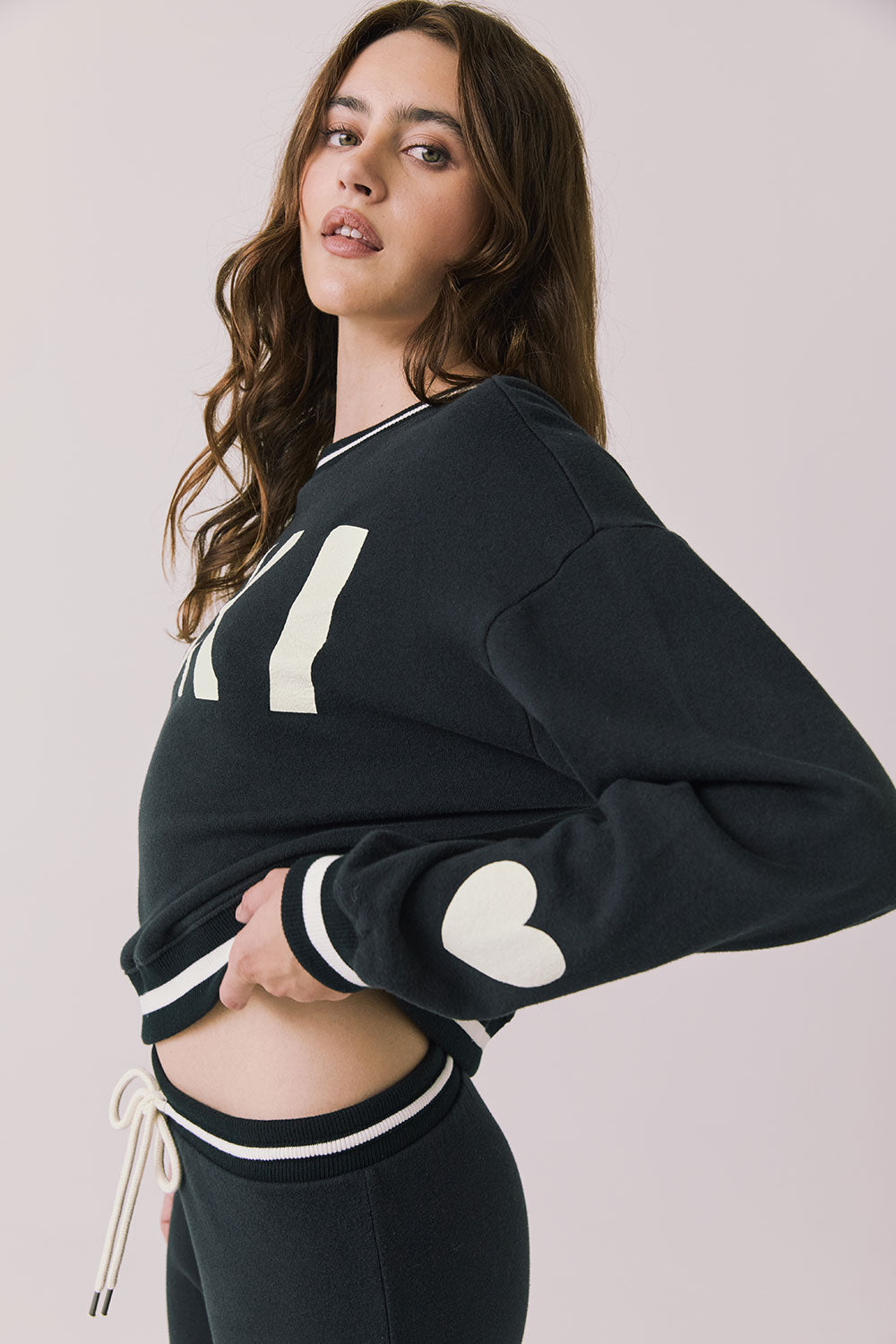 Side view of woman wearing Chaser’s Ski True Black Long Sleeve Pullover on a white background