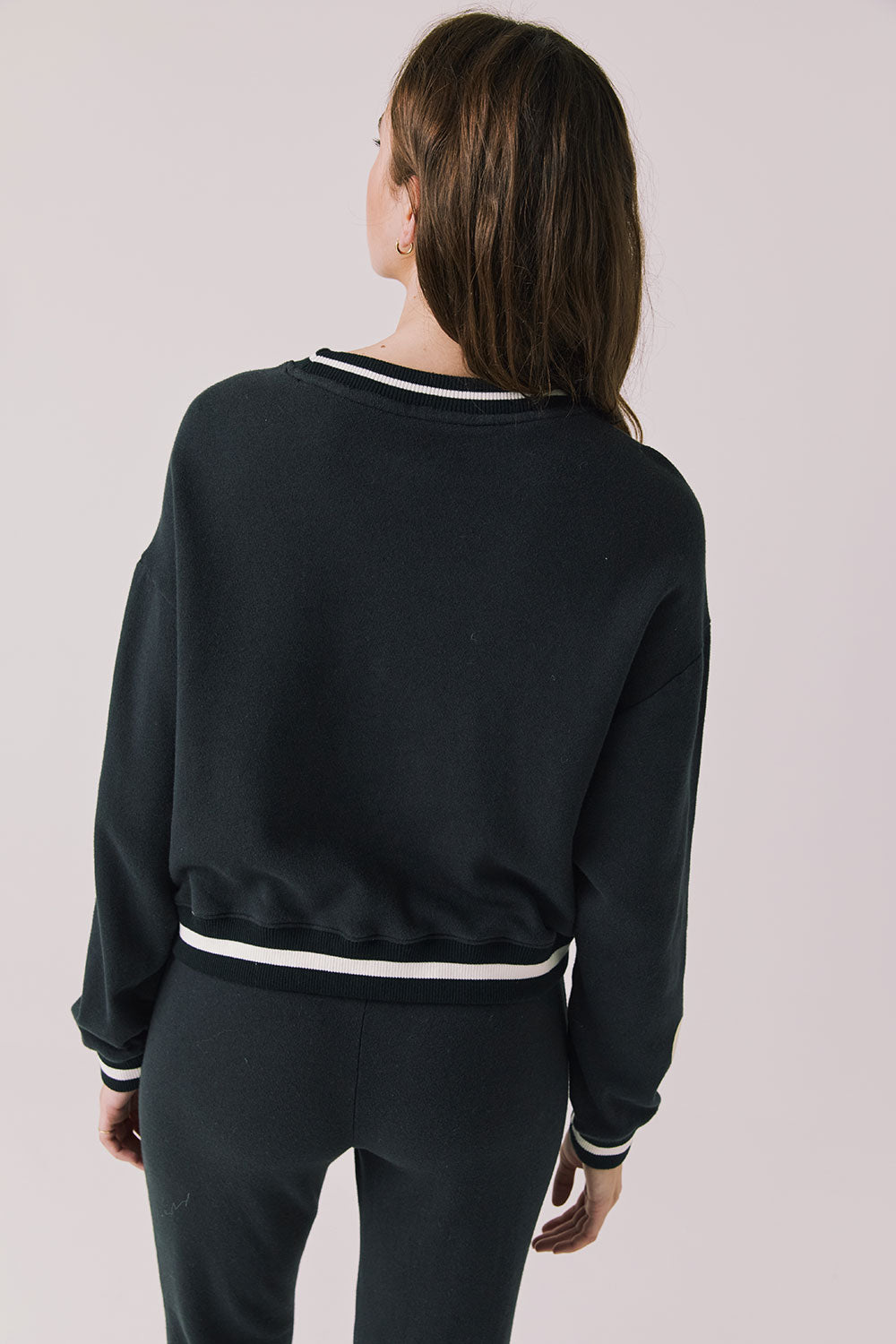 Back view of woman wearing Chaser’s Ski True Black Long Sleeve Pullover on a white background