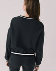 Back view of woman wearing Chaser’s Ski True Black Long Sleeve Pullover on a white background