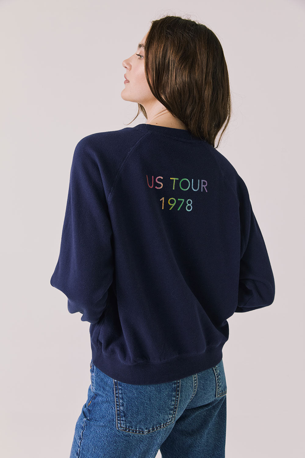 Back view of woman wearing Chaser’s The Rolling Stones US Tour 1978 Long Sleeve in Oxford Blue with tour cities text on a white background