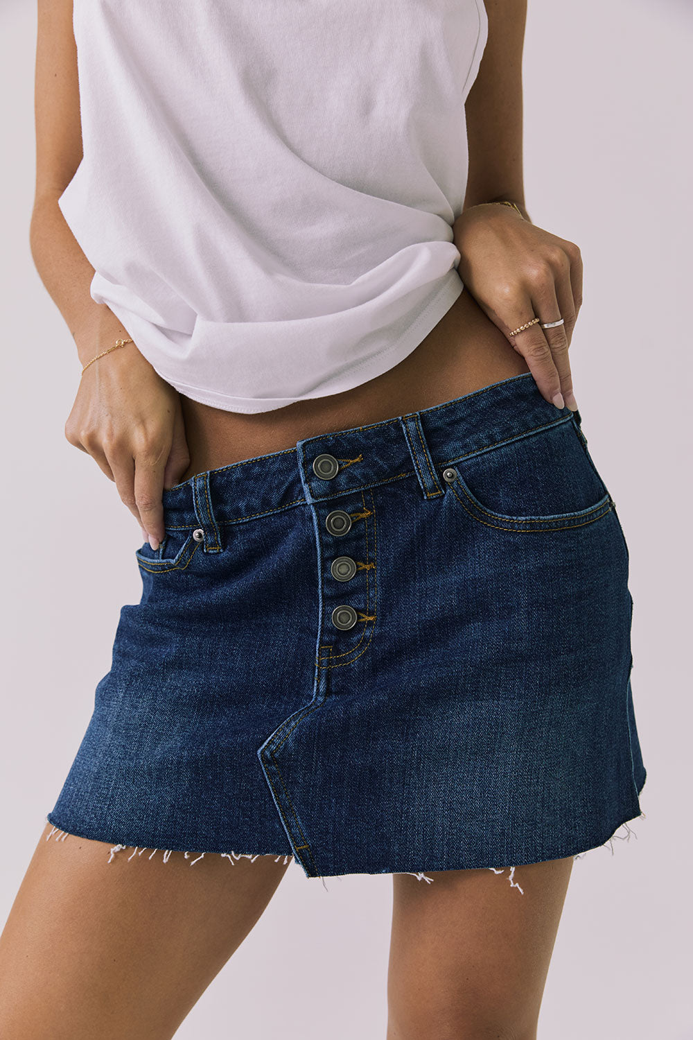 Close-up front view of the Chaser Sloane Indigo Wash Mini Skirt highlighting the button fly and waistband