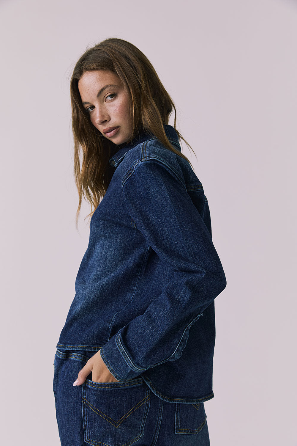 Chaser All Day Indigo Wash Button Down in Indigo Wash photographed from a soft side view highlighting the sleeve structure and smooth drape