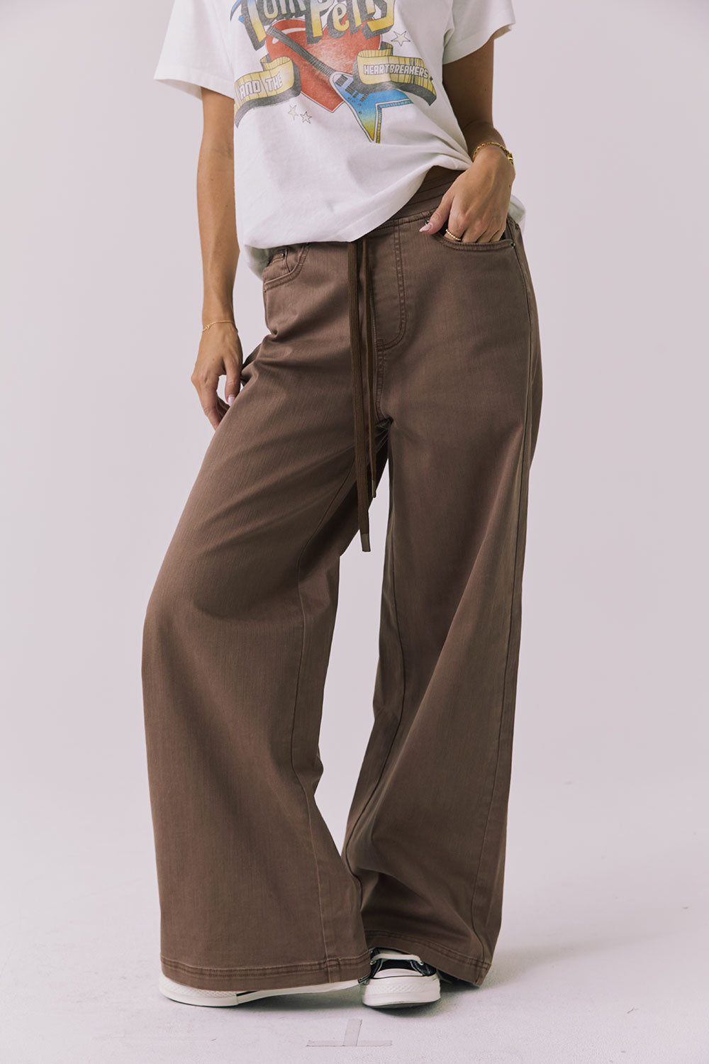 Front view of a woman wearing Chaser's Layover Cognac Wash Jogger against a plain background