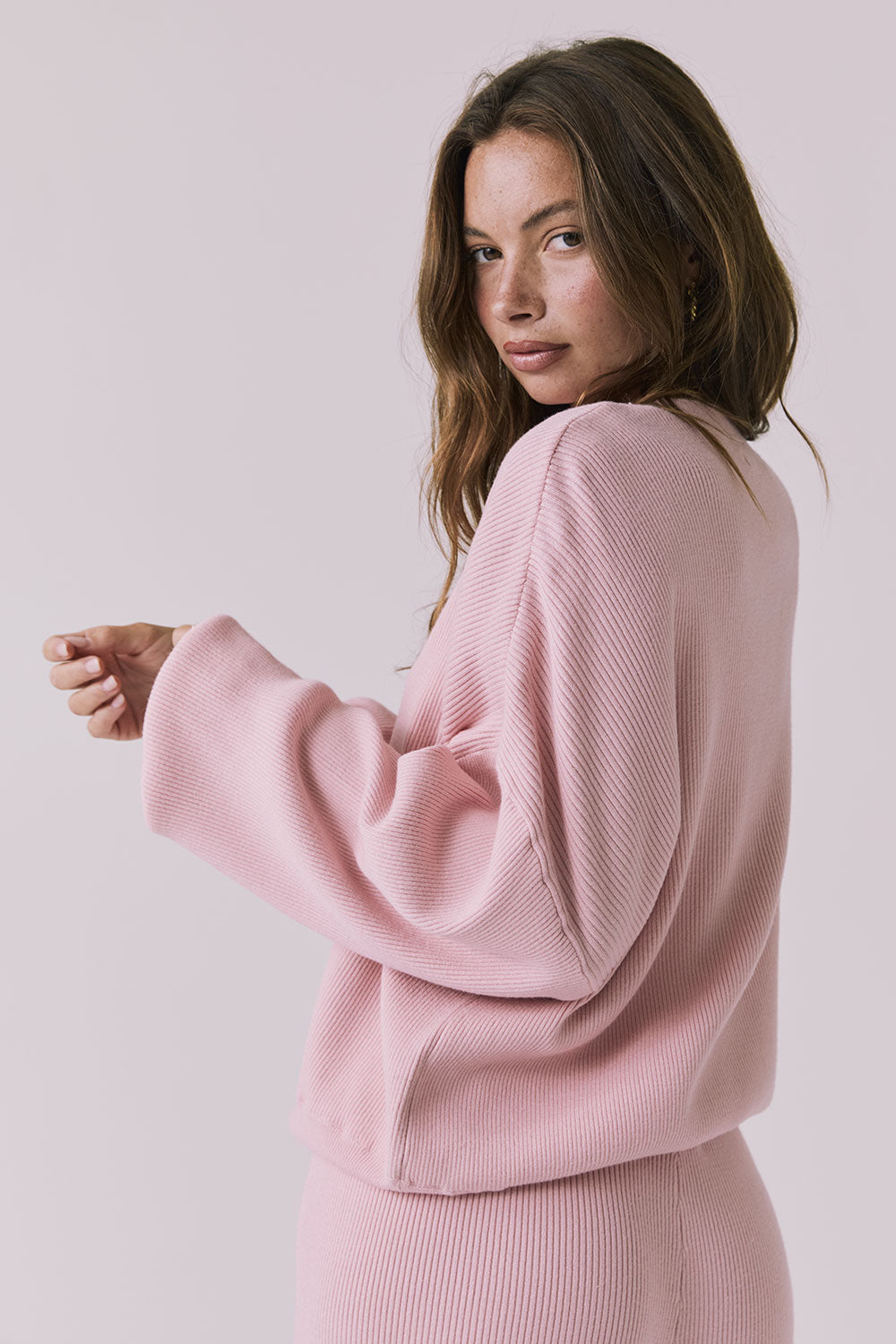 Three-quarter view of the Chaser Rhode Pink Salt Pullover showing the draped fit and wide sleeves