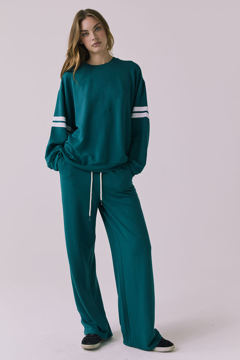 Saltwater Luxe Sandi Joggers in Teal with White side stripes shown full body paired with the matching Cornell Pullover on a model against a plain studio background