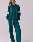 Saltwater Luxe Sandi Joggers in Teal with White side stripes shown full body paired with the matching Cornell Pullover on a model against a plain studio background