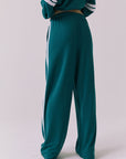 Saltwater Luxe Sandi Joggers in Teal with White side stripes shown from the back highlighting the relaxed fit and elastic waistband with the matching Cornell Pullover partially visible