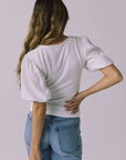 Back view of a model wearing Chaser Brands Abbie White Blouse with soft ruching and puff sleeves