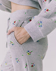 Side detail of the Chaser Brandy Heather Grey Ditsy Embroidery Crop Joggers showing a hand-in-pocket fit and ditsy embroidery on the textured waffle knit