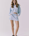 Chaser Soleil Blue Bird Mini Skort in Blue Bird styled with the matching Abilene Zip Up Hoodie in a coordinated lounge set with an easy sporty silhouette