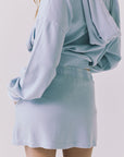 Chaser Soleil Blue Bird Mini Skort in Blue Bird styled with the matching Abilene Zip Up Hoodie showing the elastic waistband and smooth back silhouette