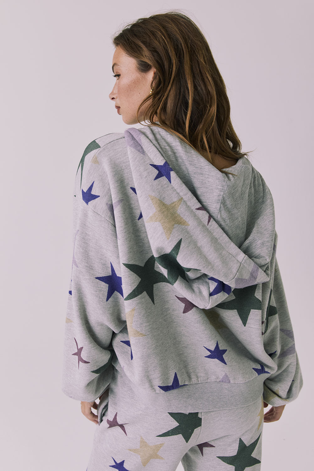 Back view of the Chaser You’re A Star Zip Up Hoodie in Heather Grey showcasing the allover star print and relaxed silhouette