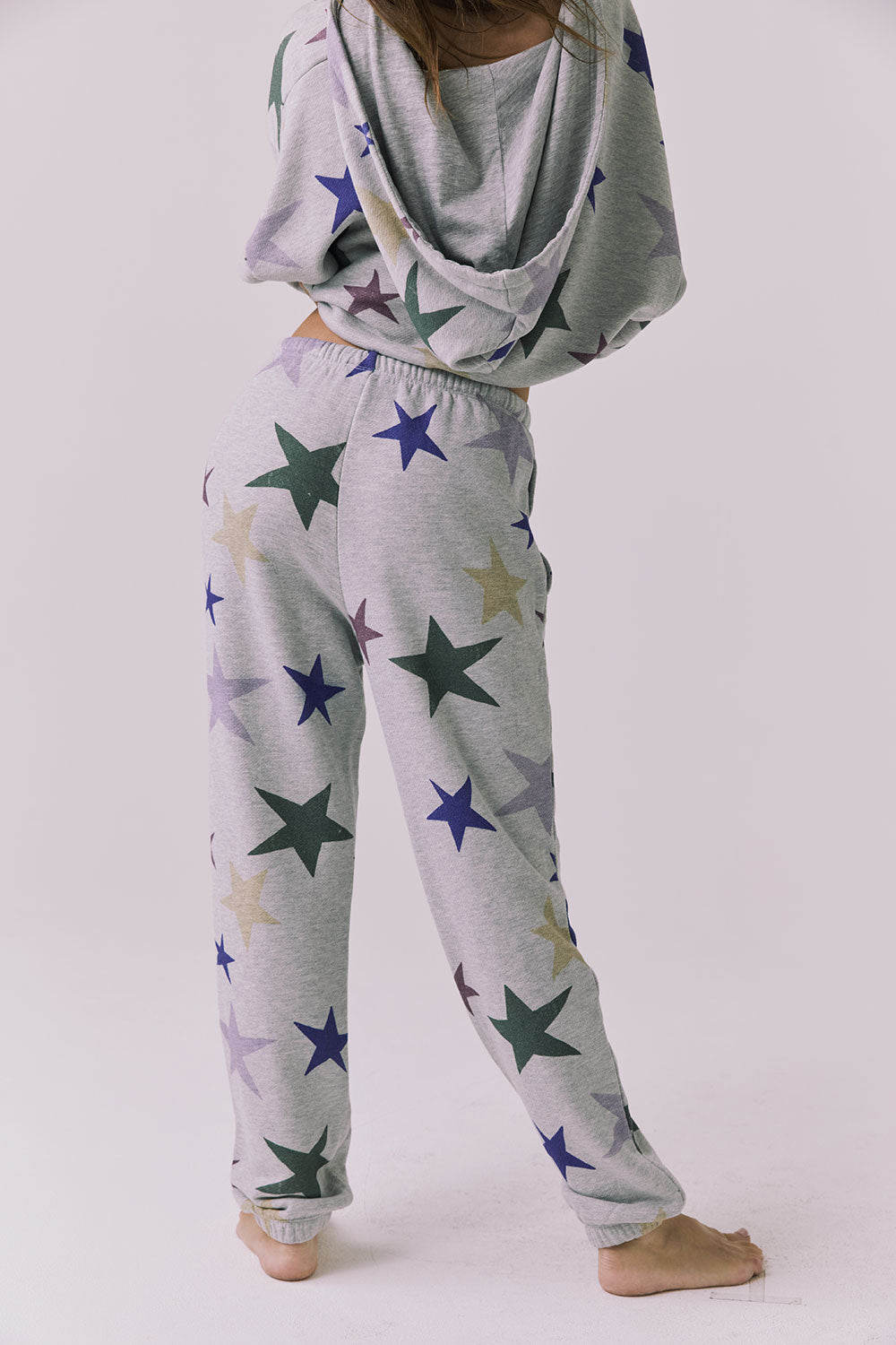 Back view of the Chaser You’re A Star Pants in Heather Grey showing the allover multicolor star print with elastic waistband and jogger cuffs S