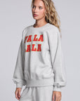 Model wearing Chaser's Fa La La La Pullover in Heather Grey with oversized red Fa La La La lettering, angled view