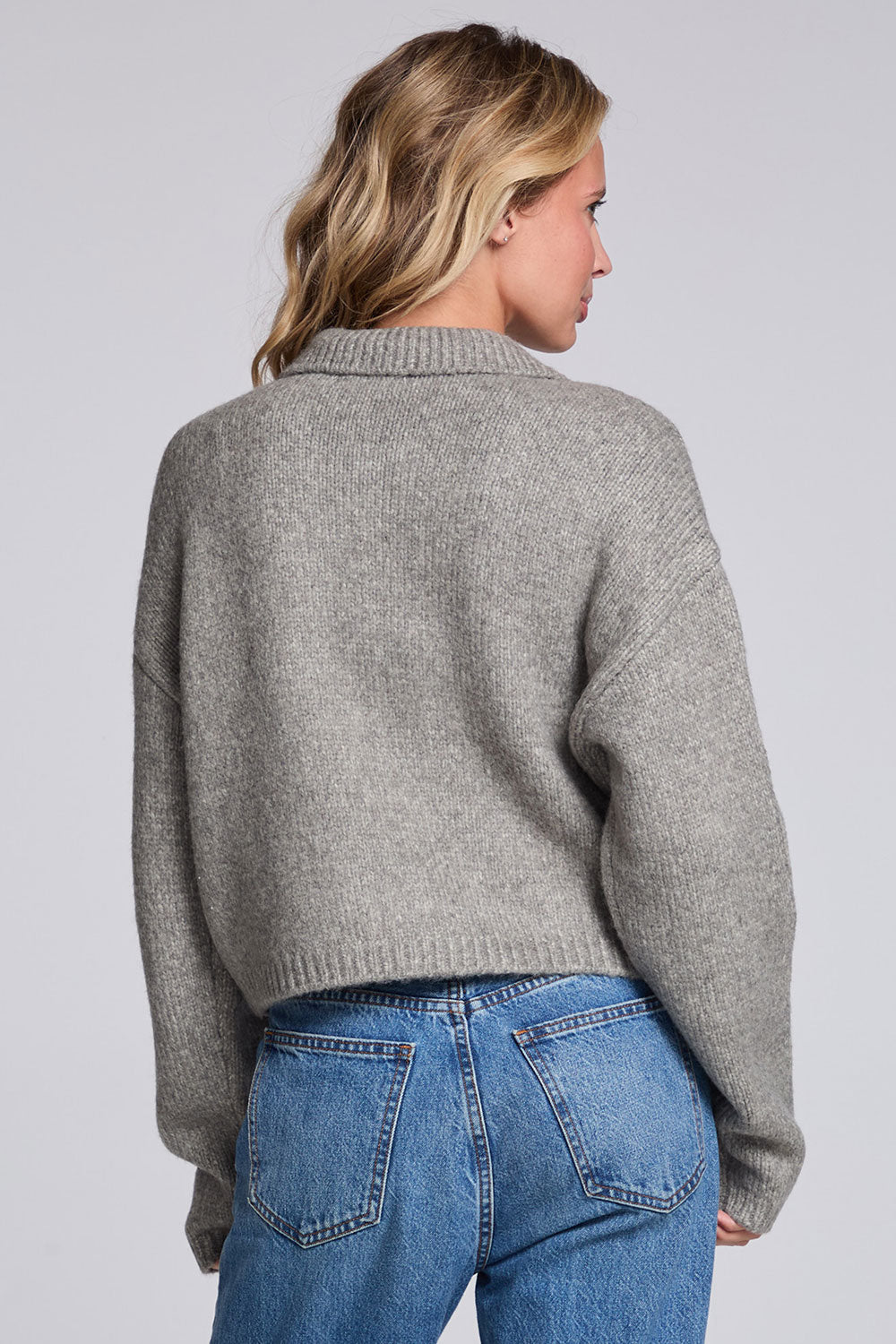 Model wearing Chaser's Winter Heather Grey Fortune Cardigan in Winter Heather Grey cropped button-front knit with pointed collar, back view