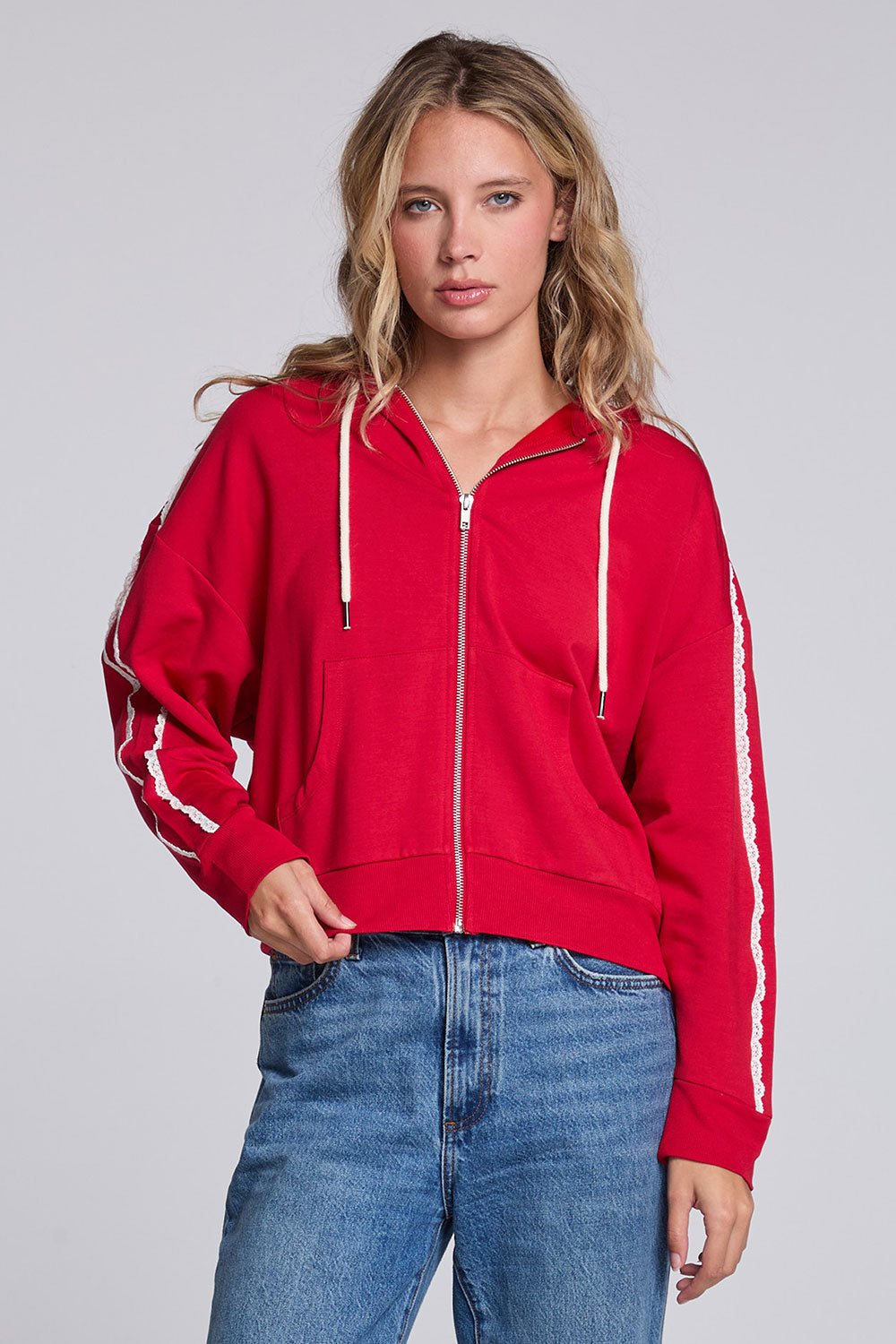 Model wearing Chaser's Cherry Bomb Emily Zip-Up in Cherry Bomb red hooded zip-up with contrast sleeve stripes, front view