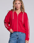 Model wearing Chaser's Cherry Bomb Emily Zip-Up in Cherry Bomb red hooded zip-up with contrast sleeve stripes, front view