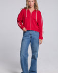 Model wearing Chaser's Cherry Bomb Emily Zip-Up and matching Delilah Track Pants in Cherry Bomb with contrast stripes, full-body view
