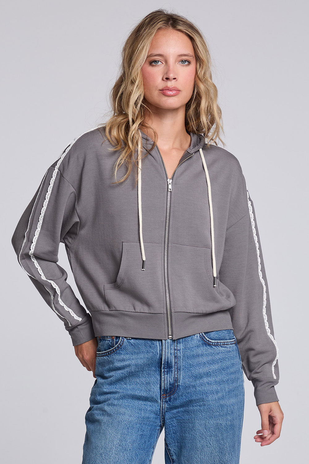 Model wearing Chaser's Soft Graphite Emily Zip-Up in Soft Graphite grey hooded zip-up with contrast sleeve stripes, front view