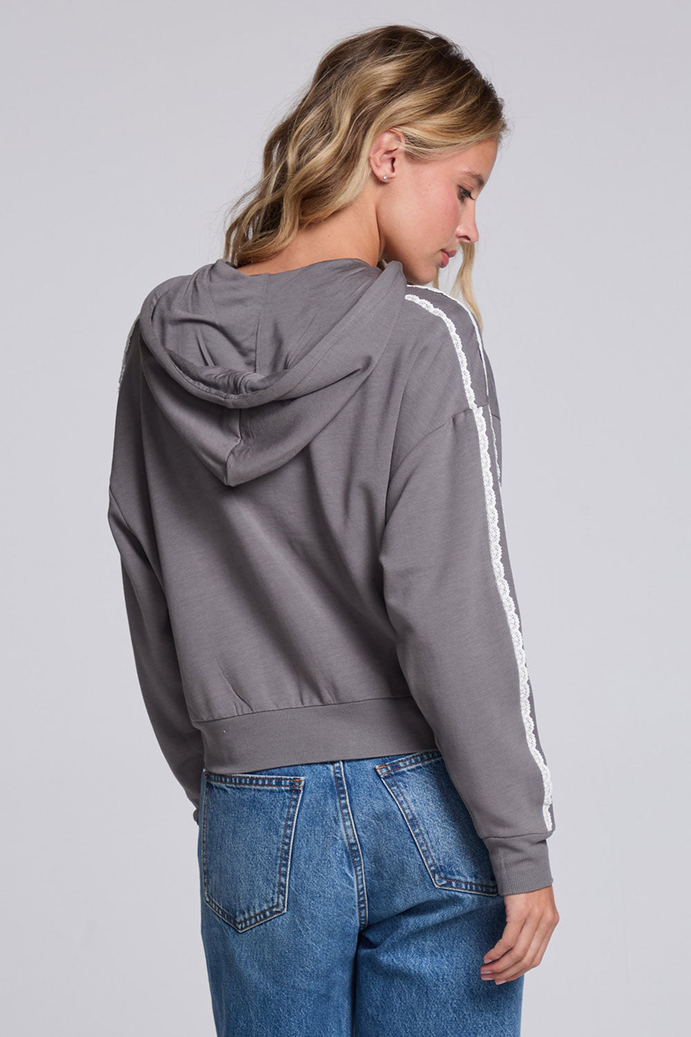 Model wearing Chaser's Soft Graphite Emily Zip-Up in Soft Graphite grey hooded zip-up with contrast sleeve stripes, back view