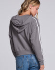Model wearing Chaser's Soft Graphite Emily Zip-Up in Soft Graphite grey hooded zip-up with contrast sleeve stripes, back view