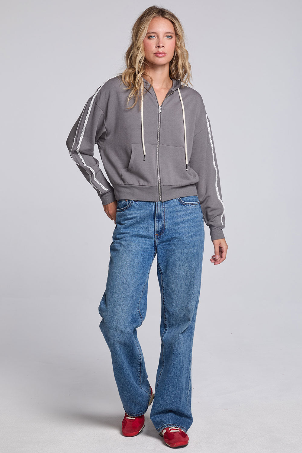 Model wearing Chaser's Soft Graphite Emily Zip-Up and matching Delilah Track Pants in Soft Graphite with contrast stripes, full-body view