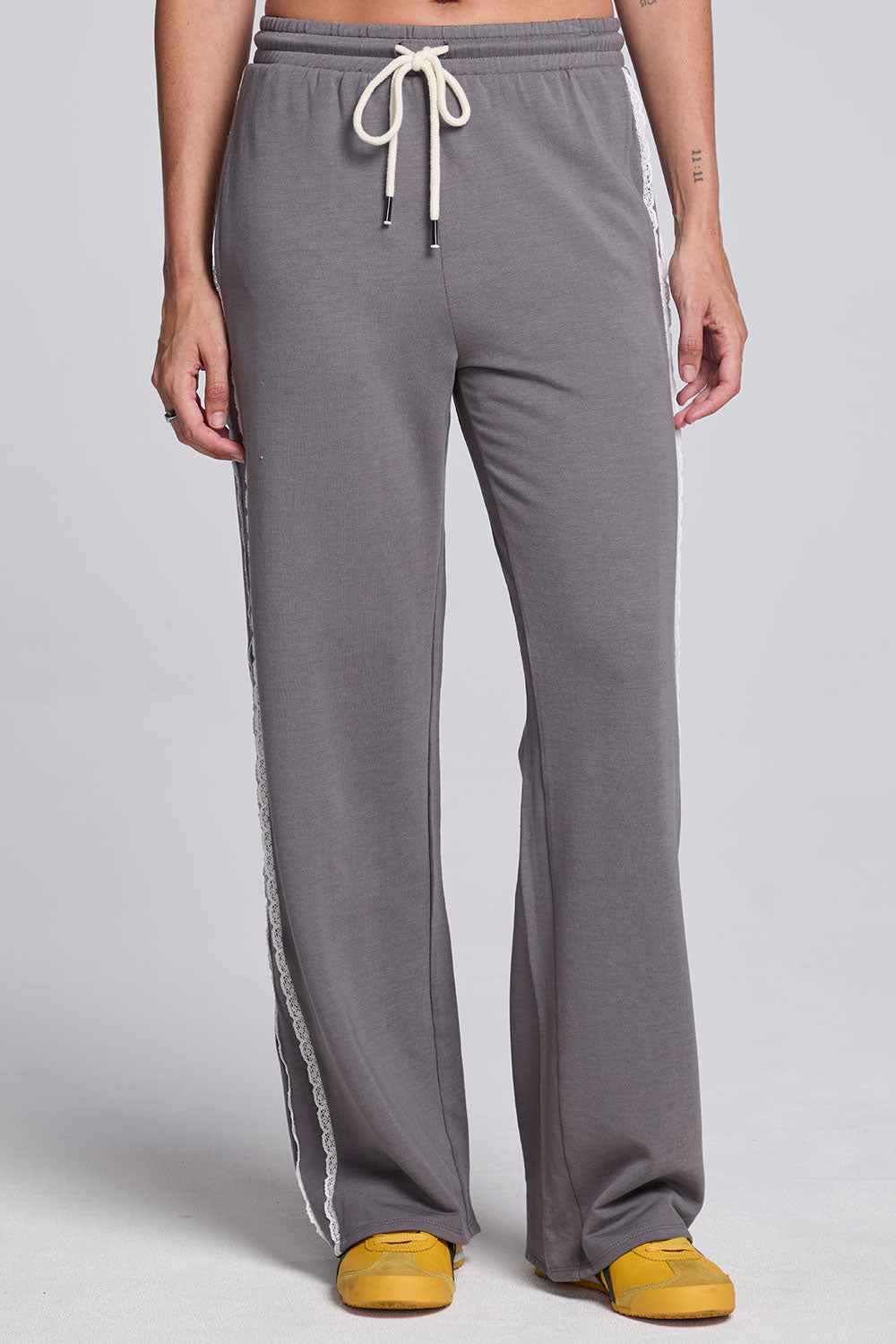 Model wearing Chaser's Soft Graphite Delilah Track Pants in Soft Graphite grey wide-leg track pants with contrast side stripes, front view